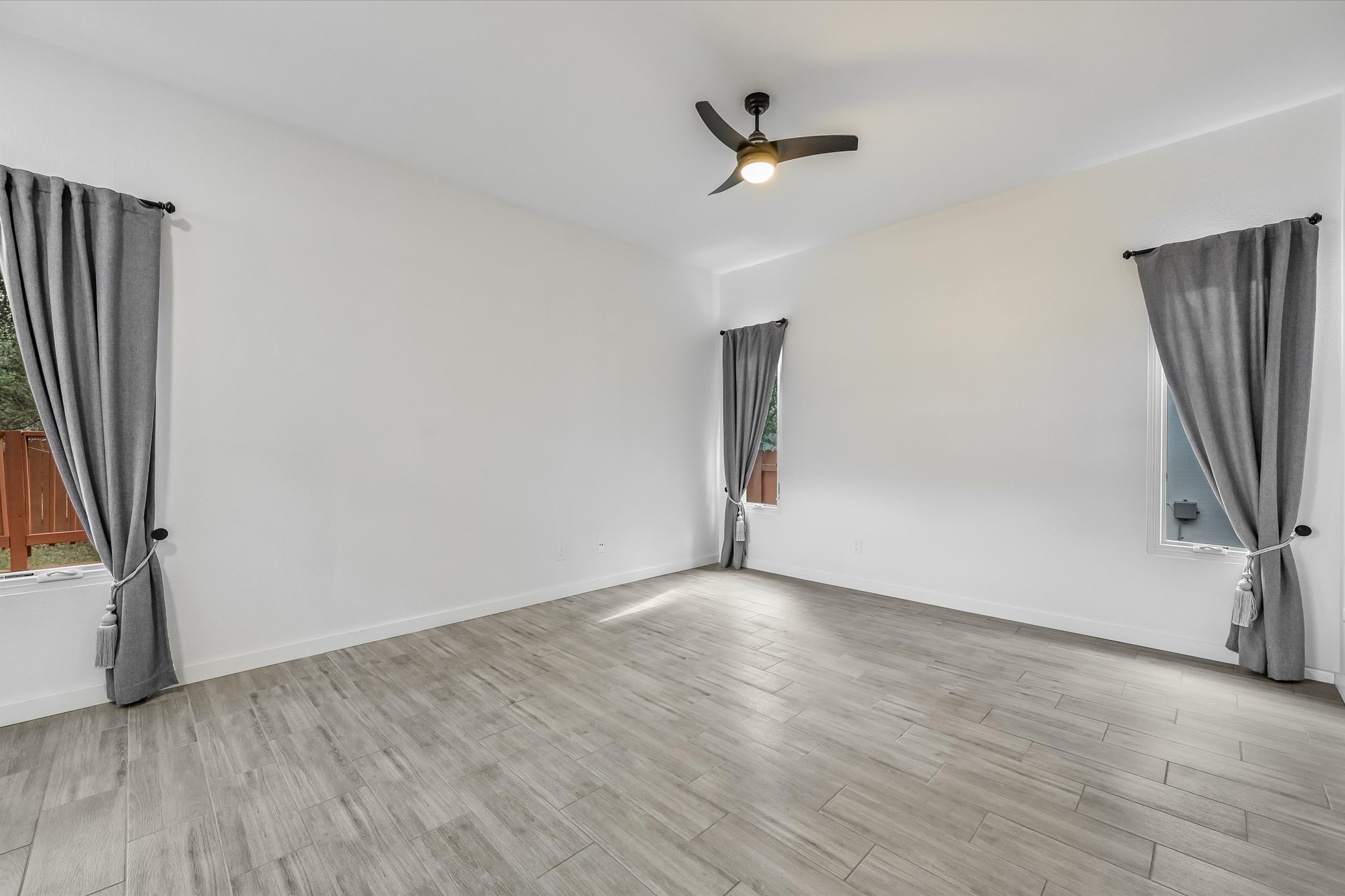 10203 Brantley Bend Austin, TX 78748 - Photo 10 of 20 Empty room with a ceiling fan, light wood-type flooring, and plenty of natural light