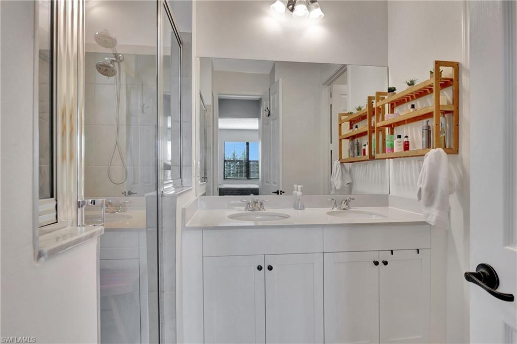 9041 Madrid Circle Naples, FL 34104 - Photo 12 of 32 a bathroom with a double vanity sink mirror and