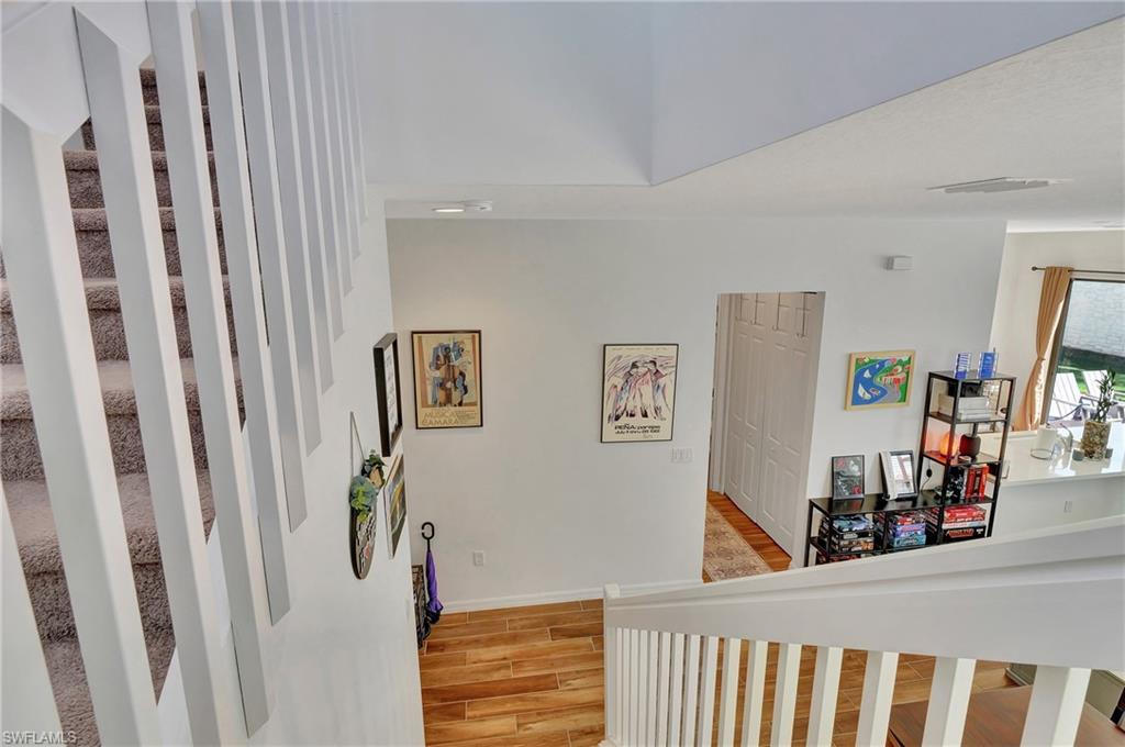 9041 Madrid Circle Naples, FL 34104 - Photo 16 of 32 a view of a hallway with workspace and wooden floor