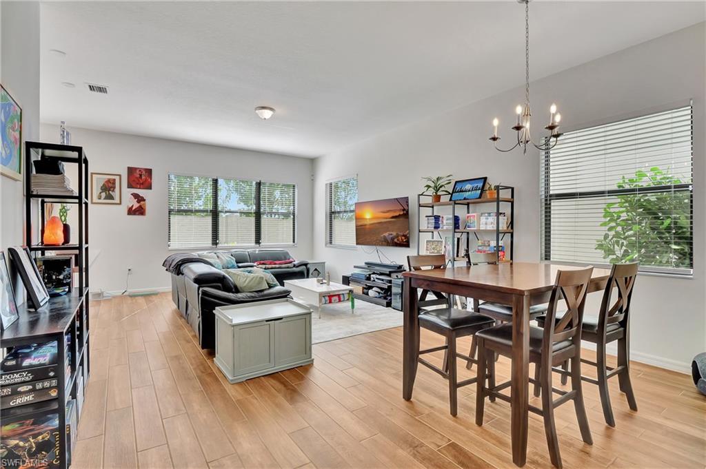 9041 Madrid Circle Naples, FL 34104 - Photo 19 of 32 a living room with furniture a window and a flat screen tv