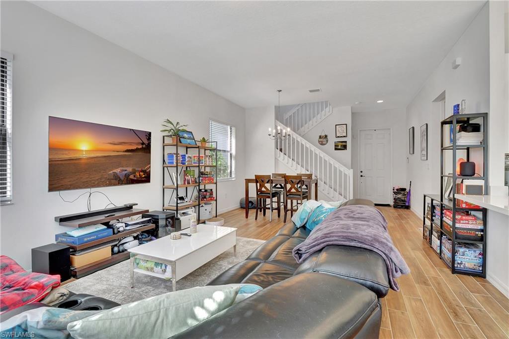 9041 Madrid Circle Naples, FL 34104 - Photo 23 of 32 a living room with furniture and a flat screen tv
