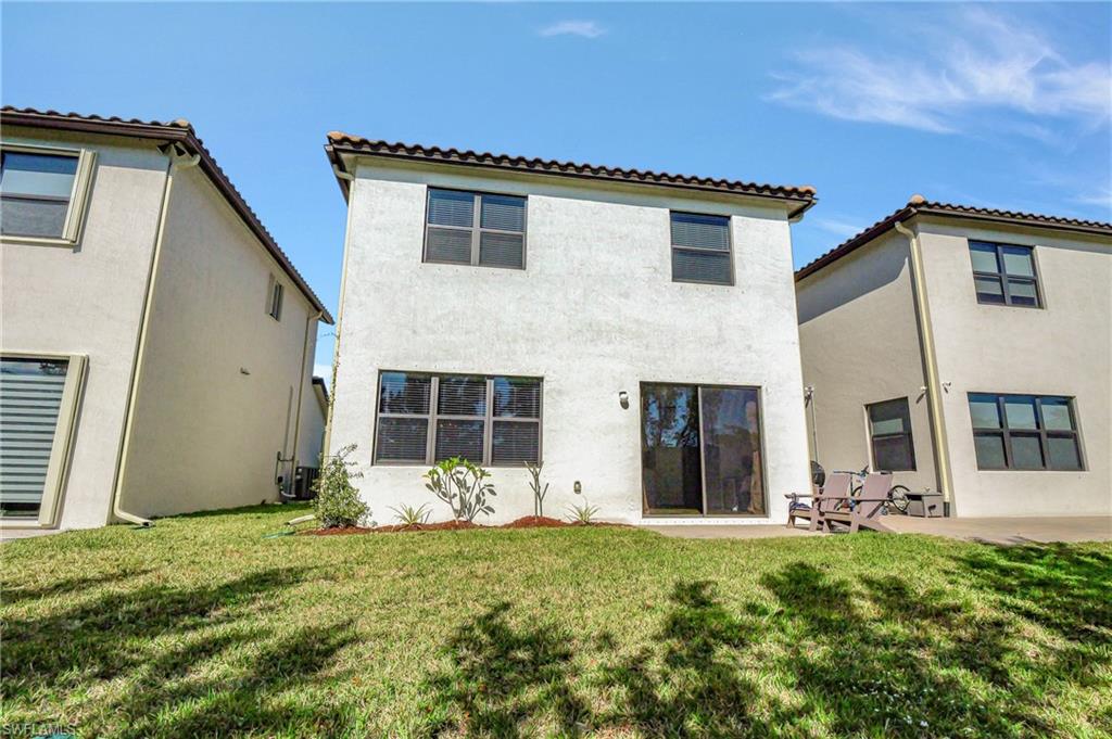9041 Madrid Circle Naples, FL 34104 - Photo 30 of 32 front view of a house with a yard