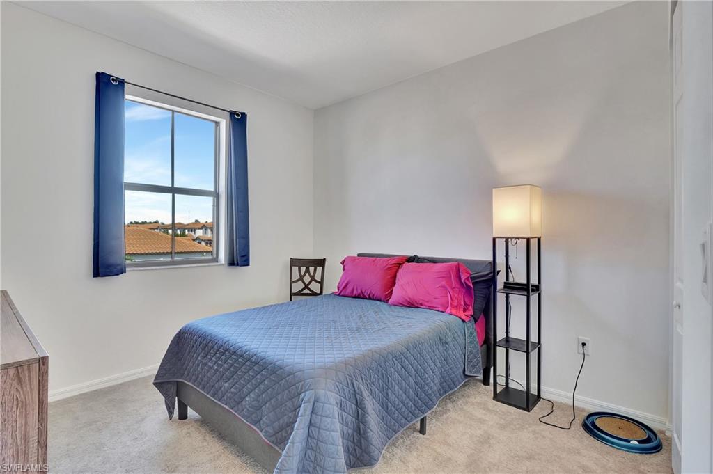 9041 Madrid Circle Naples, FL 34104 - Photo 3 of 32 a bedroom with a bed and window