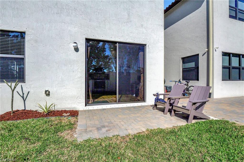 9041 Madrid Circle Naples, FL 34104 - Photo 31 of 32 a backyard of a house with table and chairs