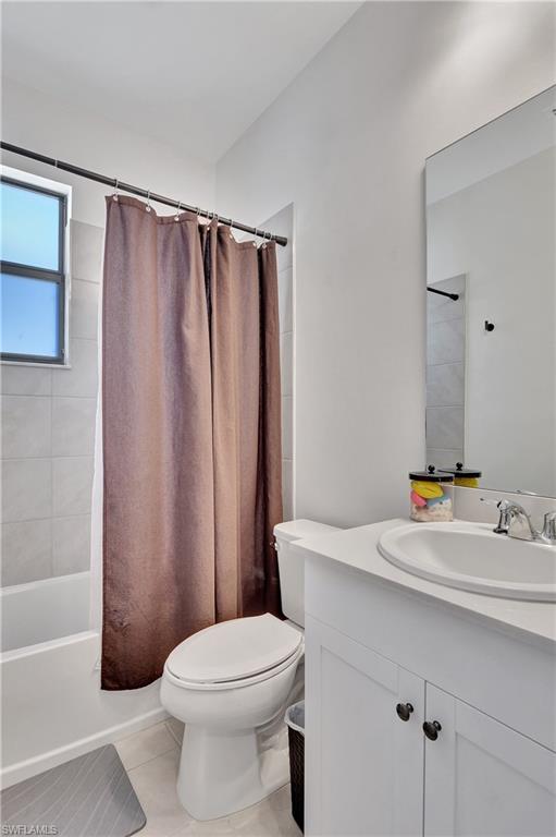 9041 Madrid Circle Naples, FL 34104 - Photo 6 of 32 a bathroom with a sink a toilet and shower