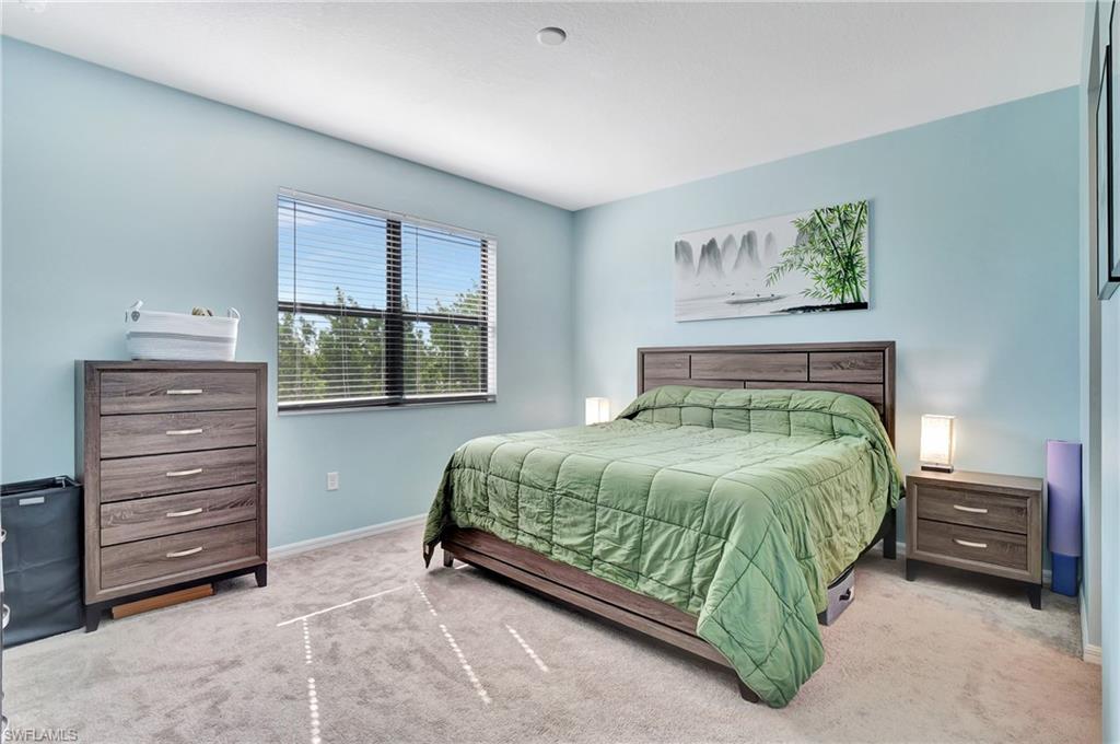 9041 Madrid Circle Naples, FL 34104 - Photo 9 of 32 a bedroom with a bed and a window