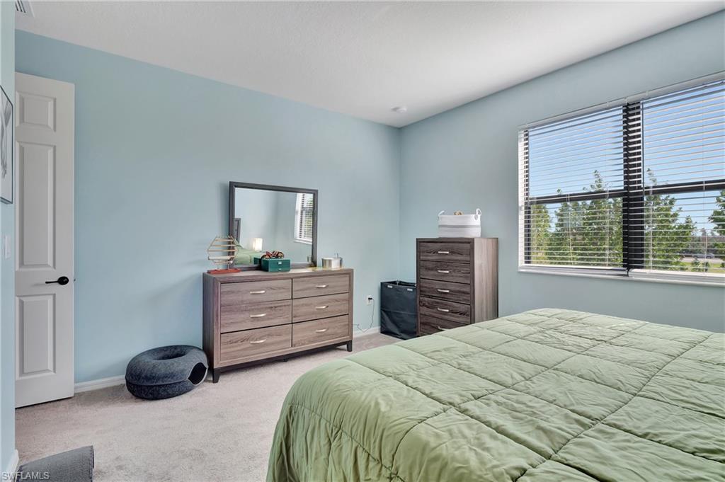 9041 Madrid Circle Naples, FL 34104 - Photo 10 of 32 a bedroom with a bed and a window