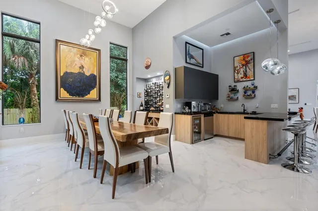 a dining hall with furniture a window and kitchen view