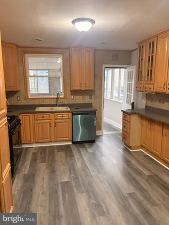 a large kitchen with wooden floors and stainless steel appliances
