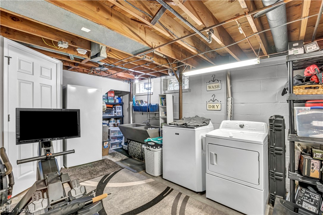 977 Lloyd Road Wickliffe, OH 44092 - Photo 30 of 38 Laundry area with exposed wood ceiling beams, concrete block walls, and a utility sink