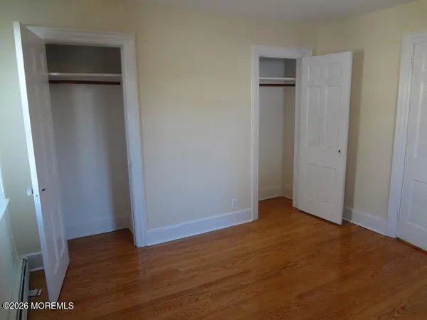 an empty room with wooden floor and closet