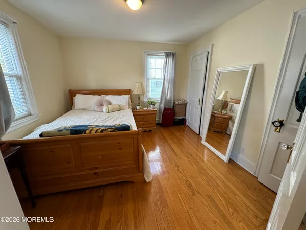 a spacious bedroom with a bed and wooden floor