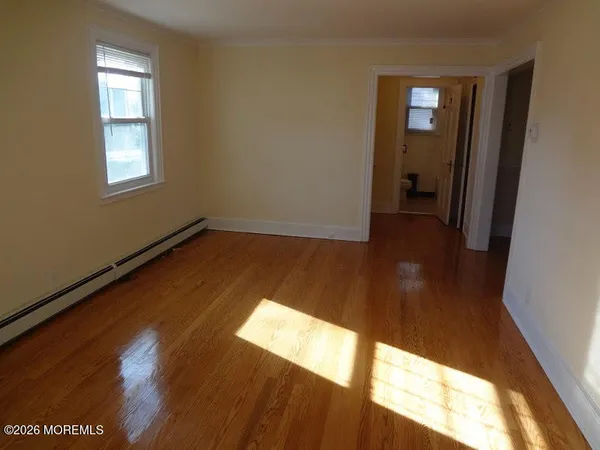 a view of a room with wooden floor and a window