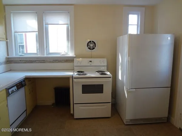 a kitchen with a refrigerator sink and cabinets