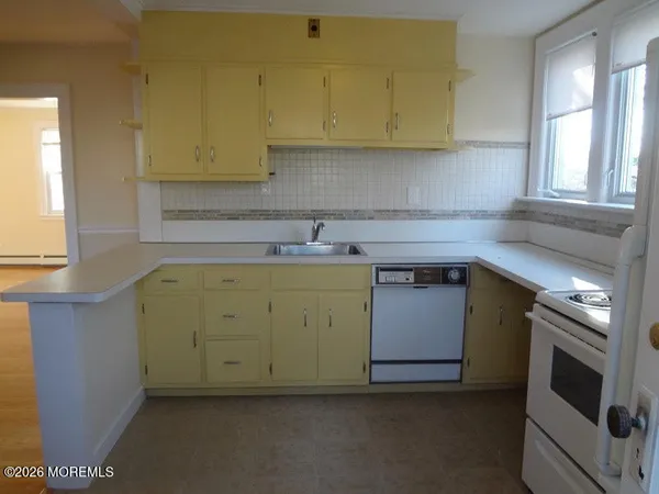 a utility room with a sink a window and stainless steel appliances