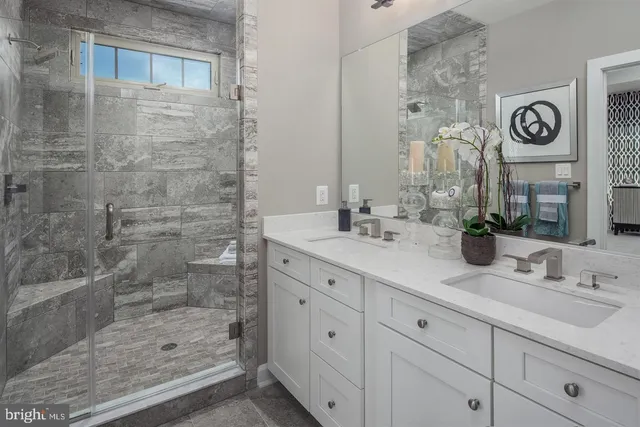 a bathroom with a granite countertop sink a mirror and shower