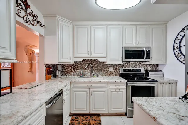 a kitchen with stainless steel appliances granite countertop a sink a stove and cabinets