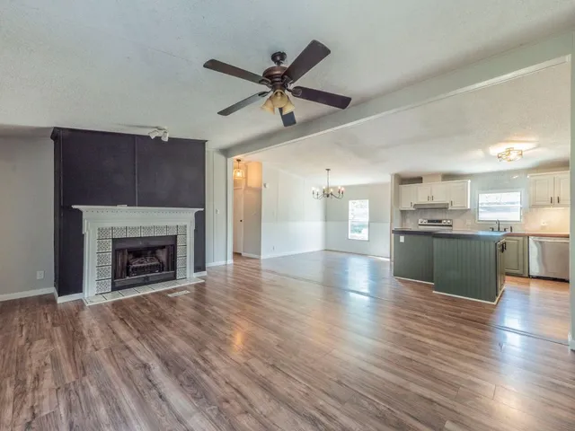 a view of a kitchen with a sink a fireplace and wooden floor