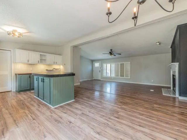 a kitchen with stainless steel appliances granite countertop a sink window and wooden floor
