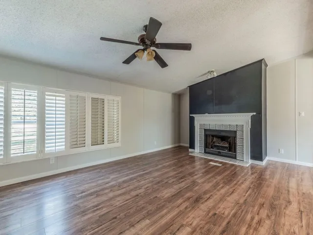 a view of empty room with wooden floor and fireplace