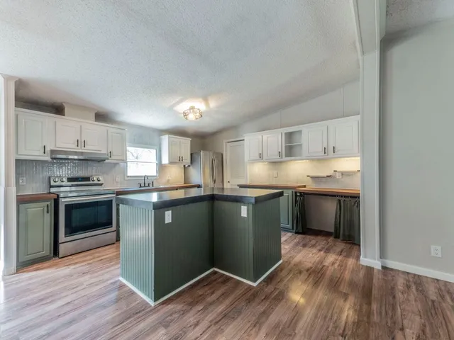a kitchen with granite countertop wooden floors and stainless steel appliances