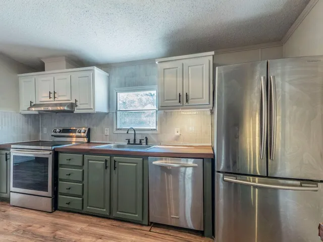 a kitchen with stainless steel appliances granite countertop a refrigerator and a sink