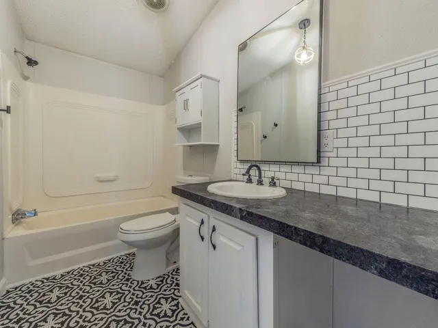 a bathroom with a double vanity sink toilet and shower