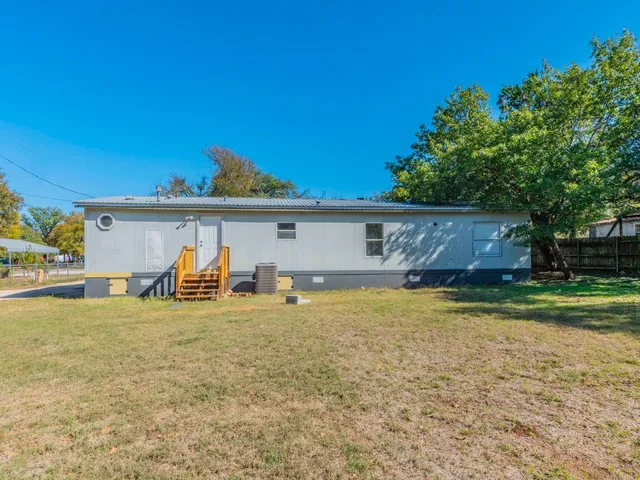 a view of a house with backyard and sitting area
