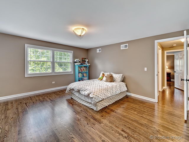 737 West Bauer Road Naperville, IL 60563 - Photo 16 of 25 a bedroom with a bed and wooden floor