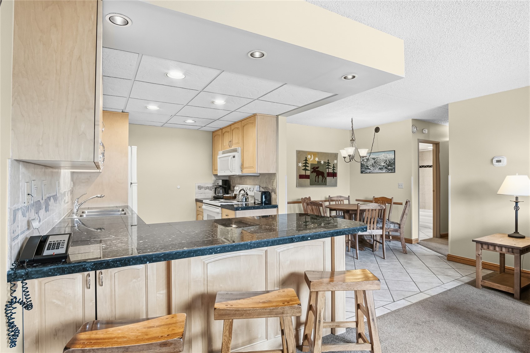 611 Village Road, Unit 24260 Breckenridge, CO 80424 - Photo 7 of 50 a kitchen with stainless steel appliances granite countertop dining table chairs sink and cabinets