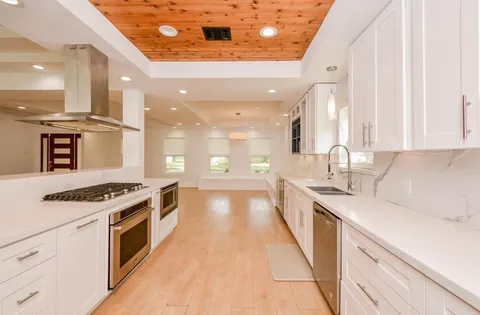 a large kitchen with stainless steel appliances granite countertop a stove and a sink