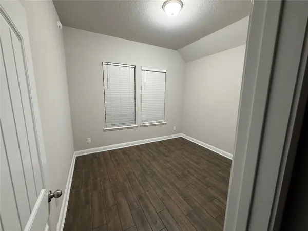 an empty room with wooden floor and window