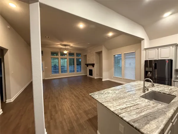 a view of kitchen island a sink wooden floor dining table and chairs