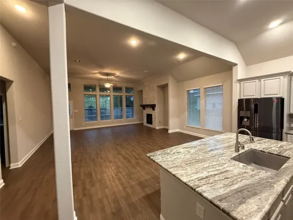 a view of kitchen island a sink wooden floor dining table and chairs