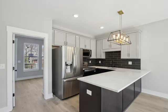 a kitchen with refrigerator cabinets and wooden floor
