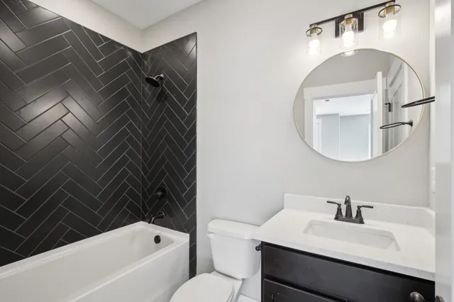 a bathroom with a sink vanity mirror and bathtub