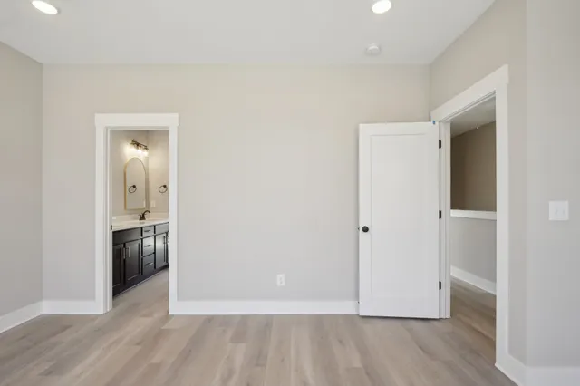 a view of an empty room with wooden floor & closet
