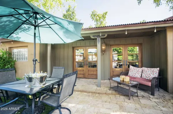 a view of a patio with table and chairs under an umbrella