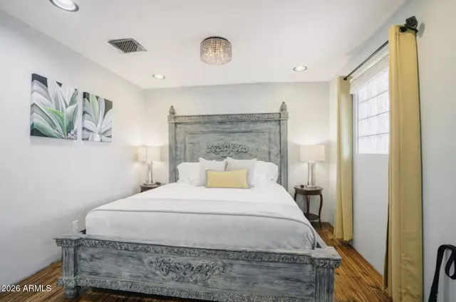 a bedroom with a bed and a painting on the wall