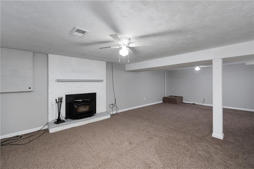 241 La Ray Drive Butler, PA 16001 - Photo 26 of 34 an empty room with a fireplace and a ceiling fan