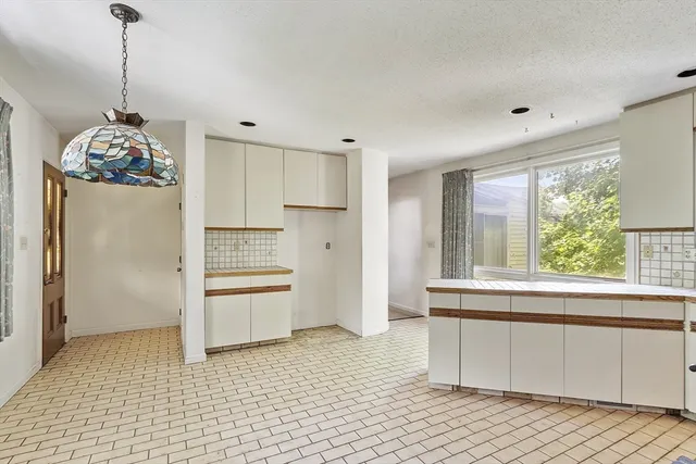 a kitchen with granite countertop white cabinets and stainless steel appliances