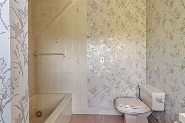 a bathroom with a toilet and a shower curtain