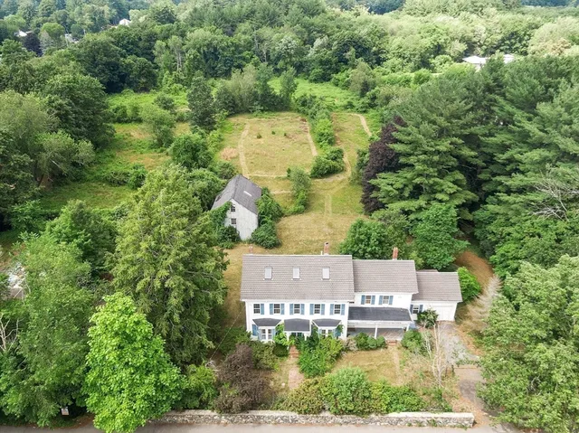 an aerial view of a house with a yard and lake view
