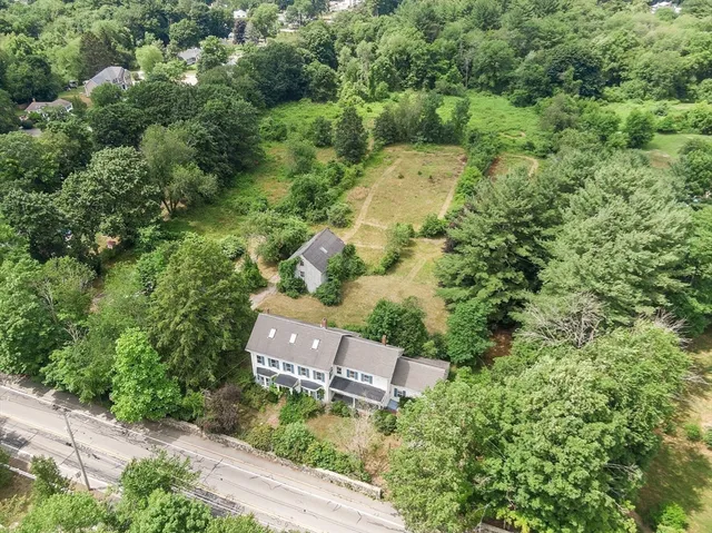an aerial view of a house with a yard and lake view