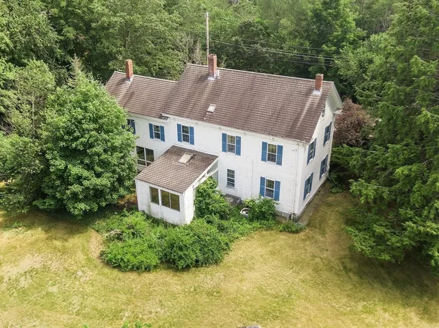 an aerial view of a house with swimming pool and garden