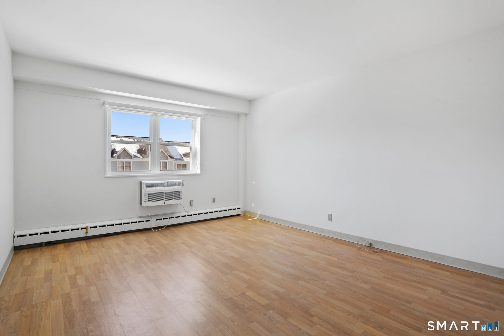 25 Cartright Street, Unit 3K Bridgeport, CT 06604 - Photo 12 of 18 an empty room with a wooden floor and a window