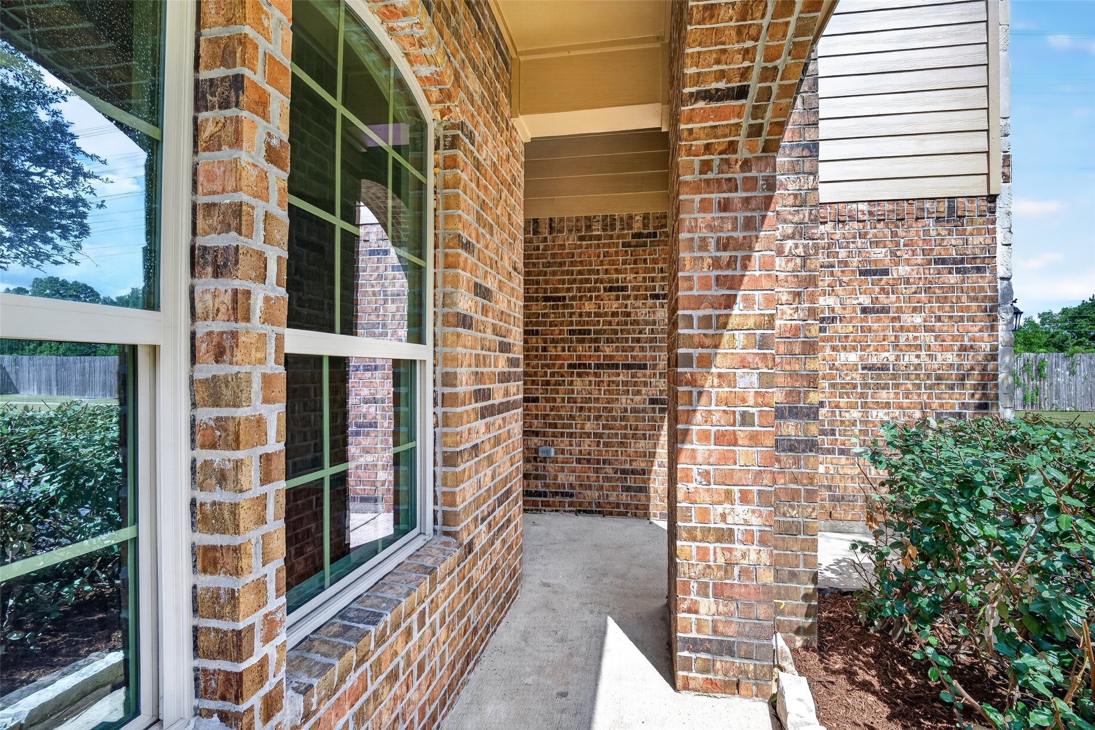 22623 Ebbets Field Drive Spring, TX 77389 - Photo 43 of 43 Another angle highlights the remarkable craftsmanship of the side porch, where dramatic arched windows draw the eye and flood the entrance with timeless character, charm, and natural light.