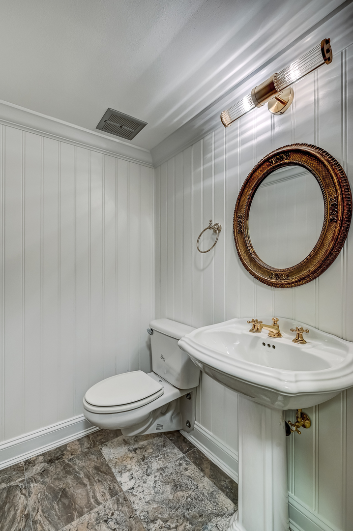 8857 Johnston Road Burr Ridge, IL 60527 - Photo 37 of 47 a bathroom with a sink a toilet and a mirror