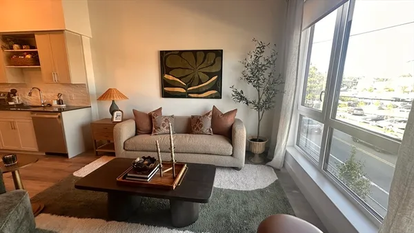 a living room with furniture a rug and a large window