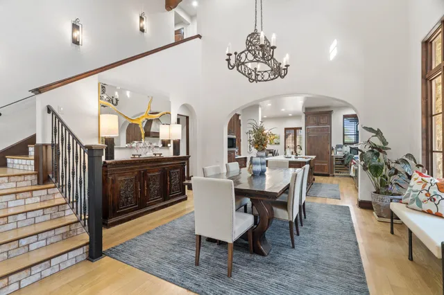 a view of a dining room with furniture a chandelier and wooden floor